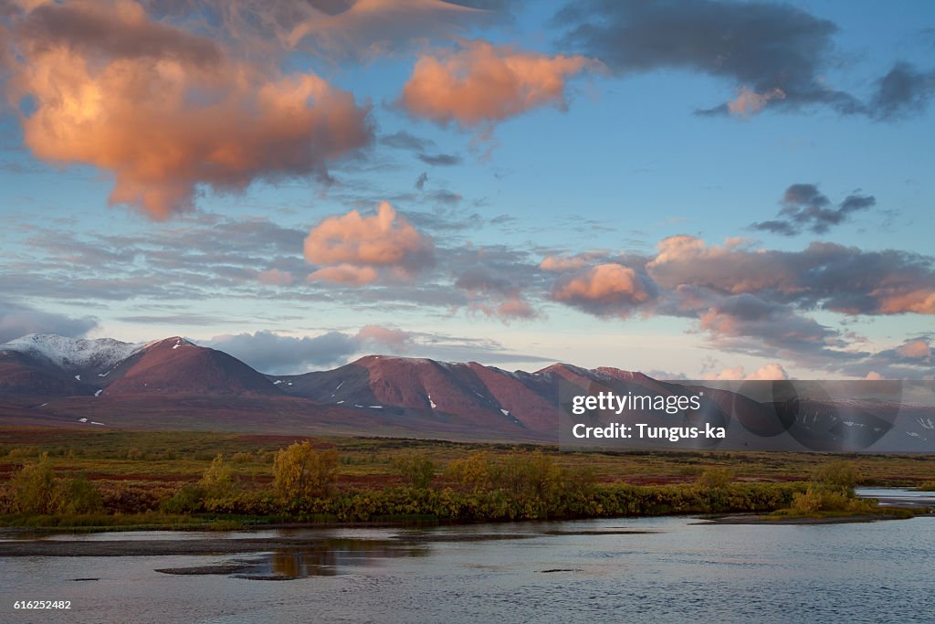 Red clouds at sunrise over the river.