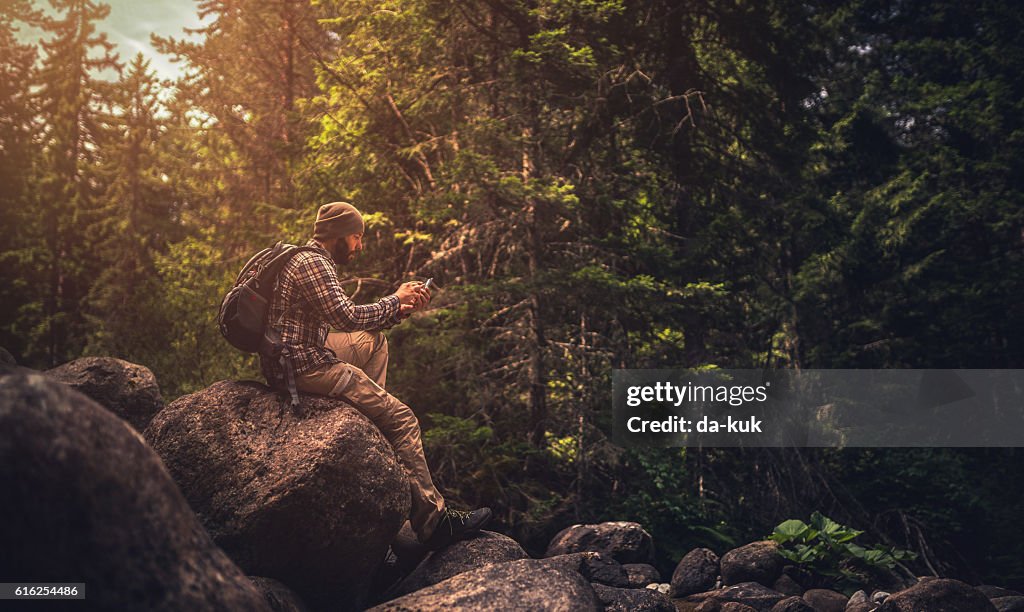 Reisende mit einem Smartphone im Wald