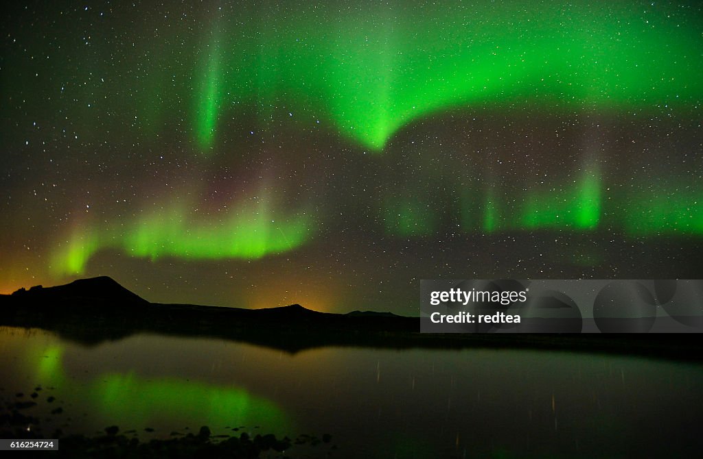 Beautiful northern lights aurora  over lake in Iceland。