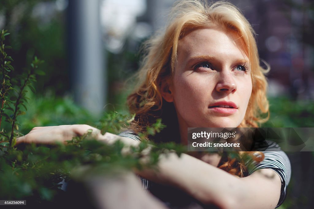 Ginger girl holding hands green branch bush photo toned