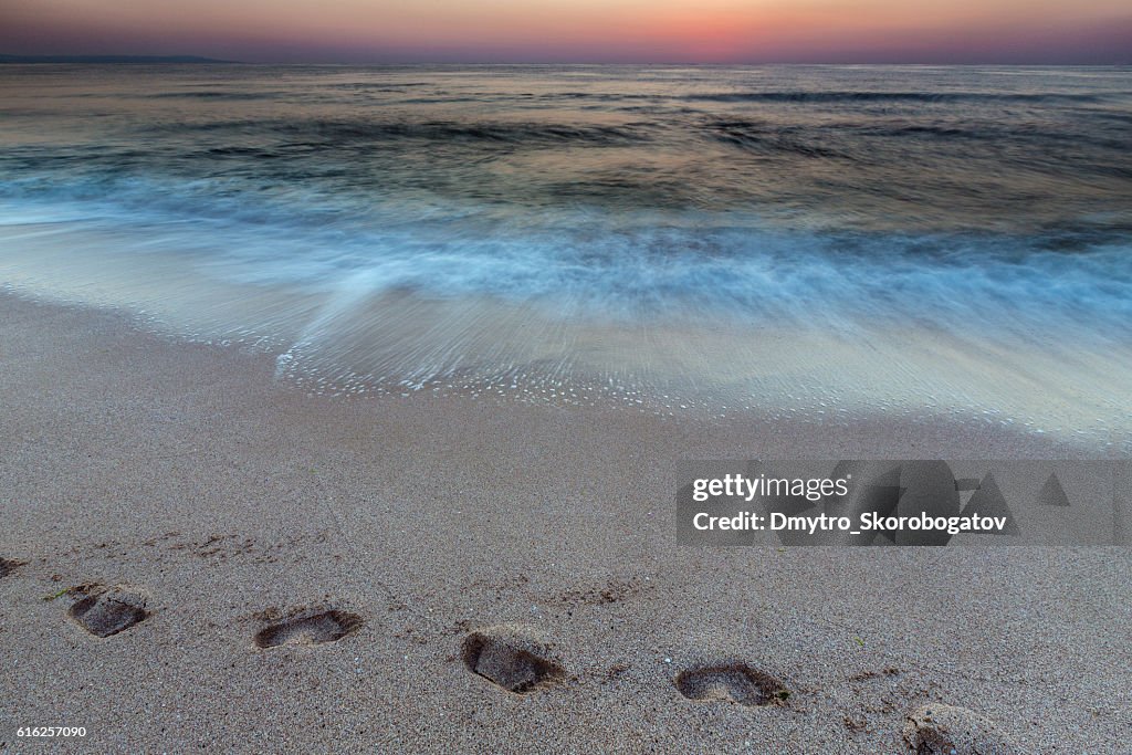 Meeresufer mit Sandstrand mit Fußspuren