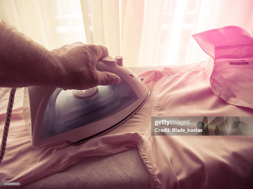 Man ironing his shirt