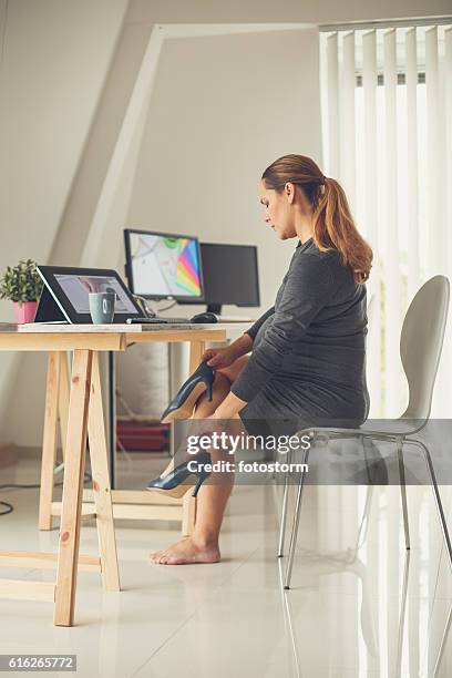 pregnant woman removing shoes - swollen ankles 個照片及圖片檔