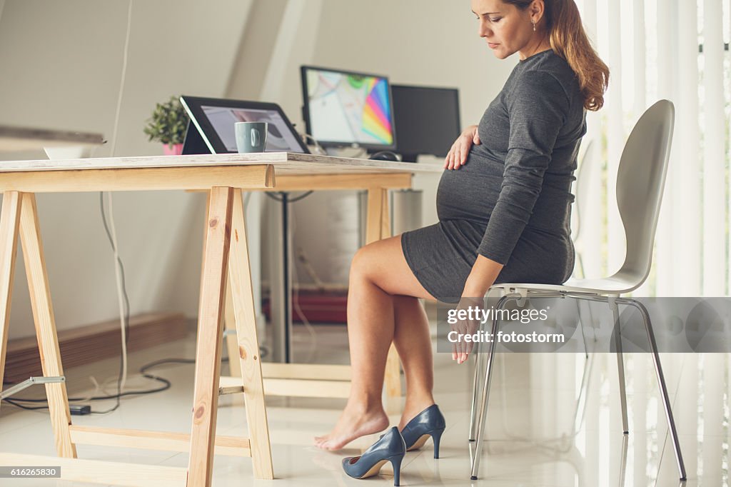 Pregnant woman taking off her shoes