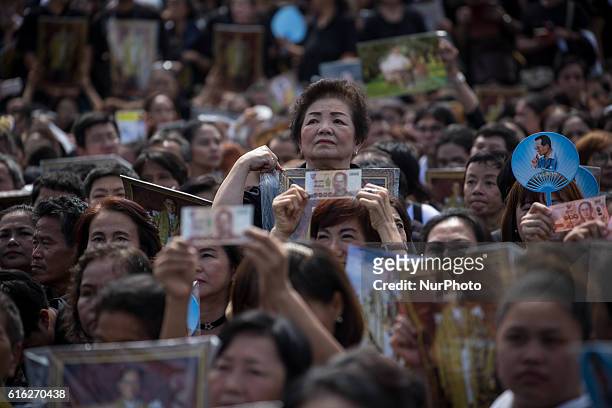 Mourners dressed in black gathers around the Grand Palace while carrying several portraits of the king as they wait to perform the Royal Anthem at...