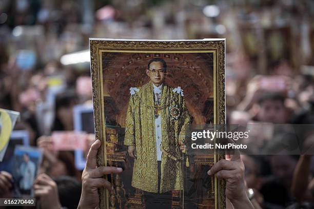 Mourners dressed in black gathers around the Grand Palace while carrying several portraits of the king as they wait to perform the Royal Anthem at...