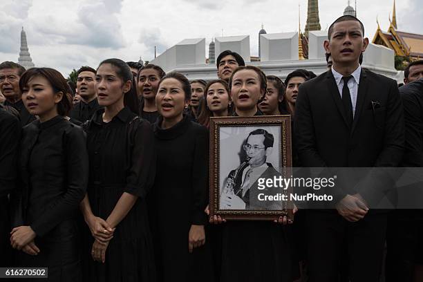 Mourners dressed in black perform the Royal Anthem at Sanam Luang front of the Grand Palace in Bangkok, Thailand on October 22, 2016. More than...