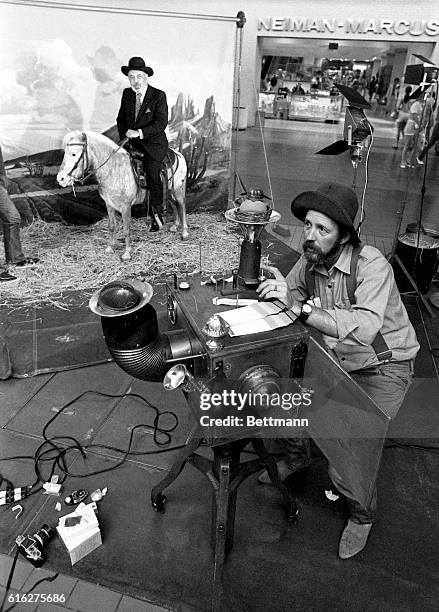 Stanley Marcus, President of the Neiman Marcus department store while Shel Hershorn readies his camera to snap a picture. The old camera is for show,...