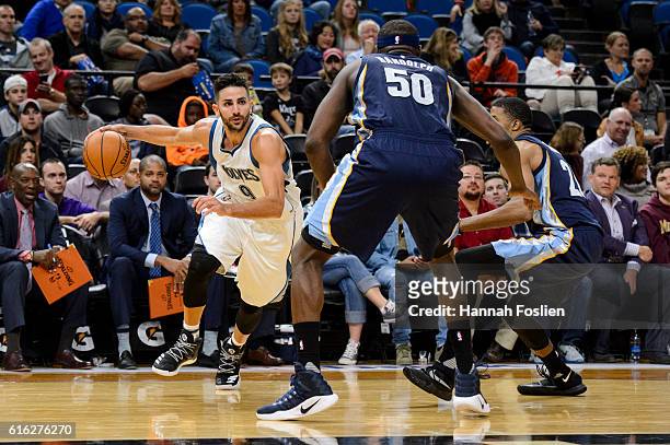 Ricky Rubio of the Minnesota Timberwolves dribbles the ball against Zach Randolph and D.J. Stephens of the Memphis Grizzlies during the preseason...