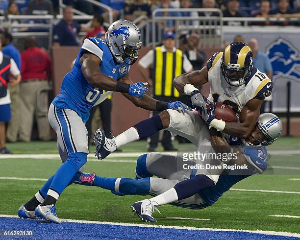 Strong safety Rafael Bush and free safety Glover Quin of the Detroit Lions stop wide receiver Kenny Britt of the Los Angeles Rams from scoring a...