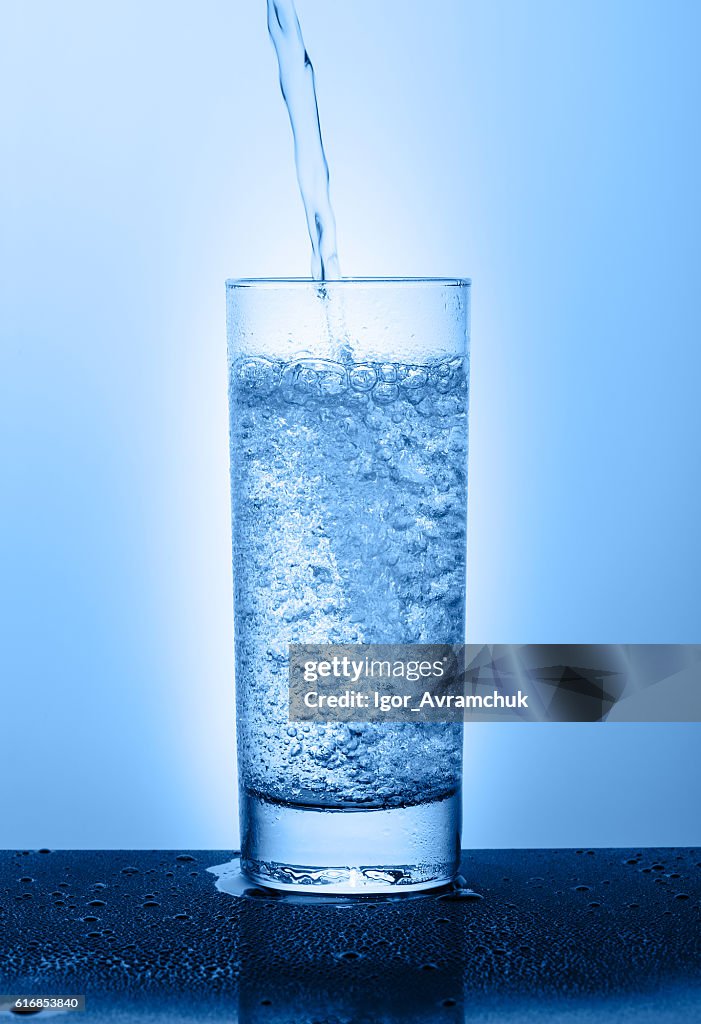 美しいガラスと水、青色の背景