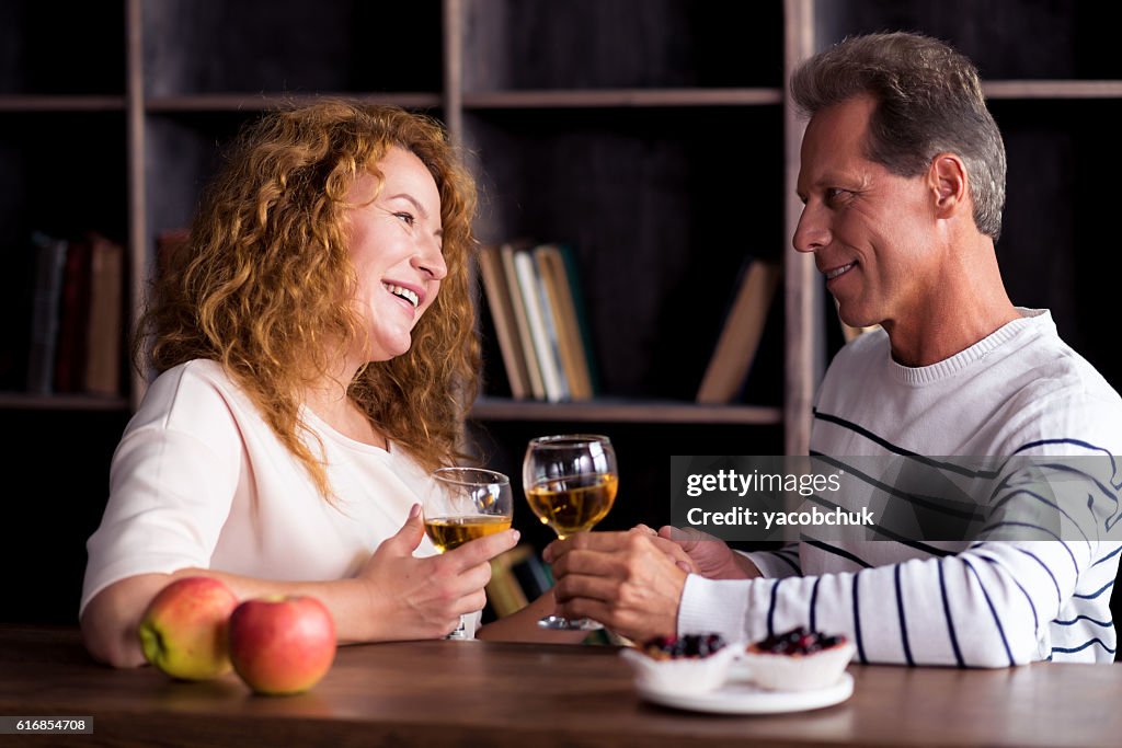 Delighted grandparents looking at each other and holding hands