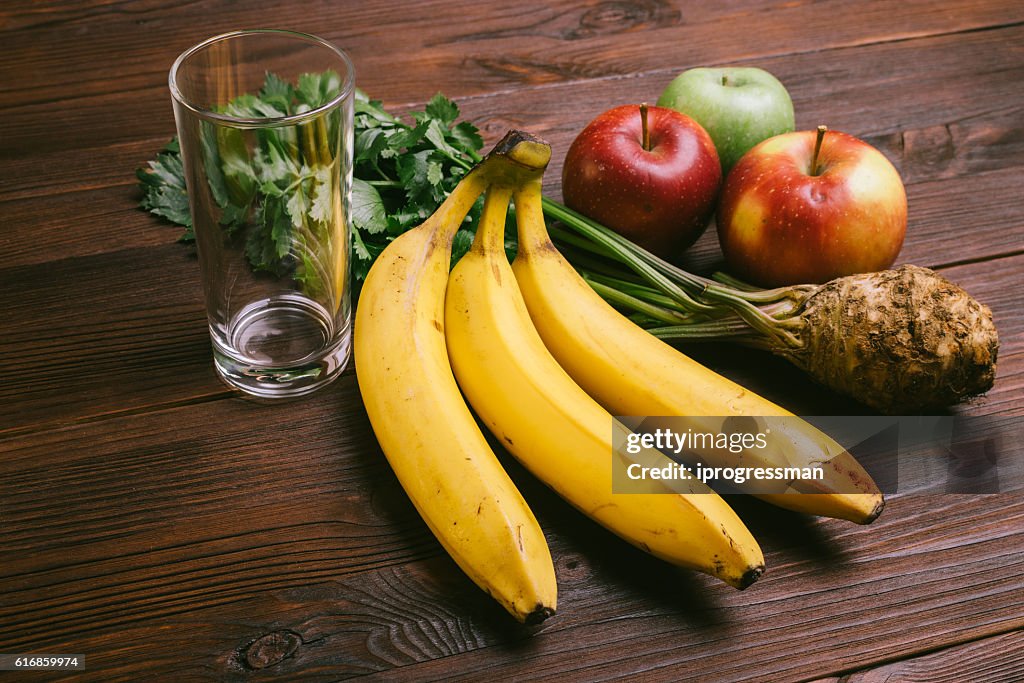 Verre vide, pommes, racine de céleri et bananes