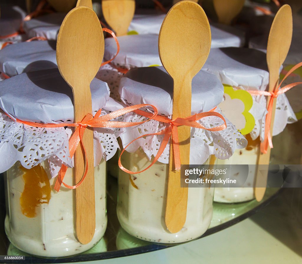 Healthy yogurt in glass jars with wooden spoons