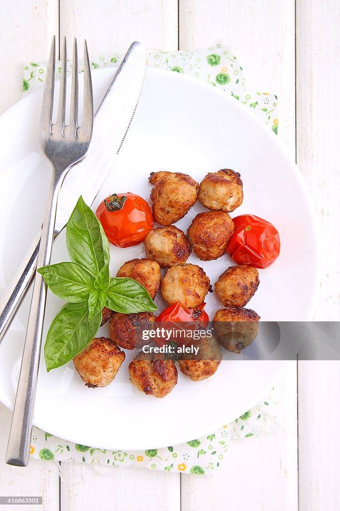 Fleischbällchen mit Tomaten in einem weißen Gericht