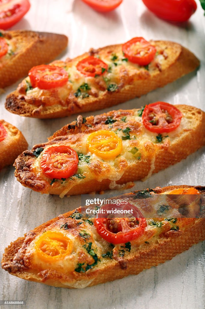 Fresh crispy toast with cheese and tomatoes on white background