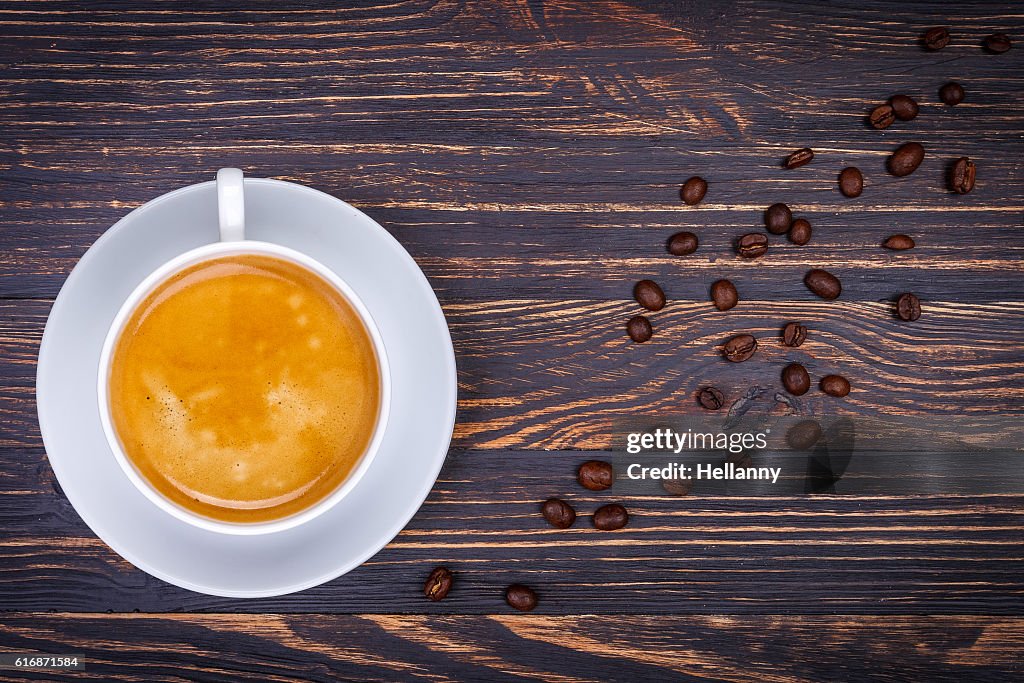 Tasse heißer Kaffee in untertasse aus Bohnen