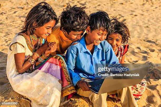 group of happy gypsy indian children using laptop, india - local gypsy stock pictures, royalty-free photos & images