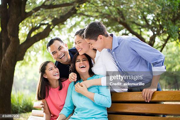 latin family laughing together outdoors - three children stock pictures, royalty-free photos & images