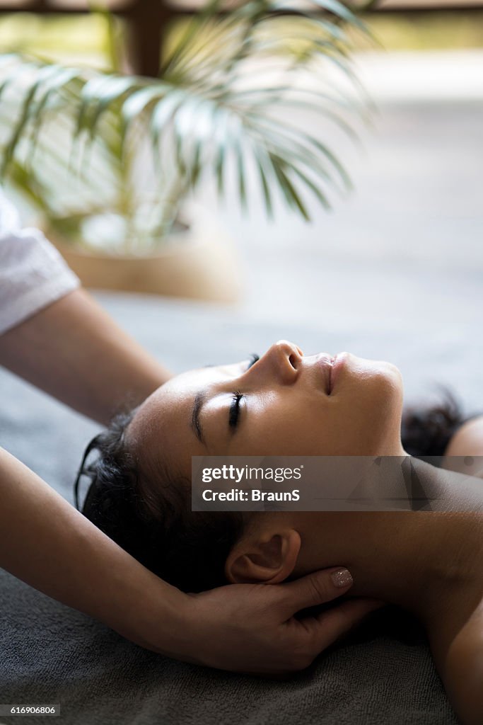 Relaxed woman having her neck massaged at the spa.