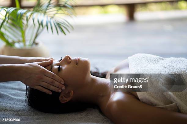 mujer malasia relajada que tiene un masaje de cabeza en el spa. - head massage fotografías e imágenes de stock