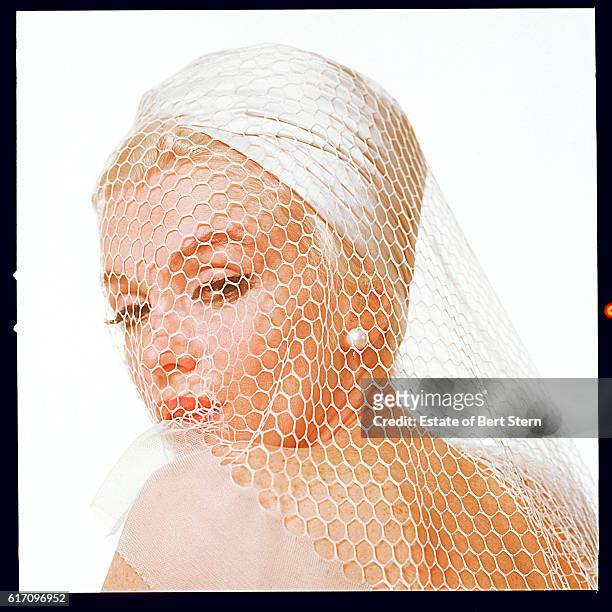 American actress Marilyn Monroe wearing a white hat and veil, Beverly Hills, California, July 1962. The two sessions for the photoshoot took place in...