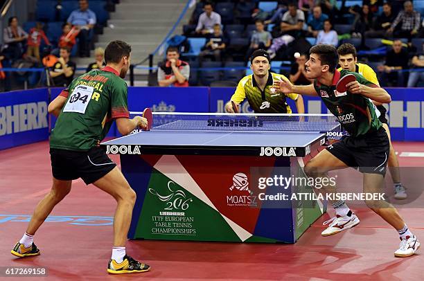 Portuguese Tiago Apolonia serves with Joao Geraldo vie against Polish Daniel Gorak and Jakub Dyjas in "Tuskecsarnok" sports hall of Budapest on...