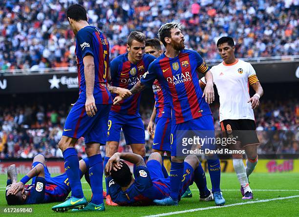 Lionel Messi of FC Barcelona celebrates with his team mates as Neymar Jr. And Luis Suarez reacts on the pitch after being hit by objects thrown from...