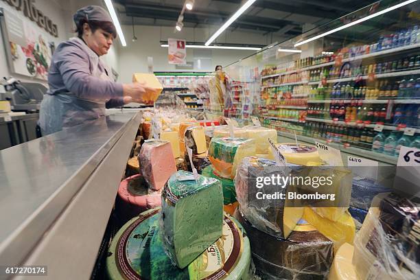 An employee arranges cheese products for display at a counter inside a Victoria supermarket operated by Dixy Group PJSC in Moscow, Russia, on Friday,...