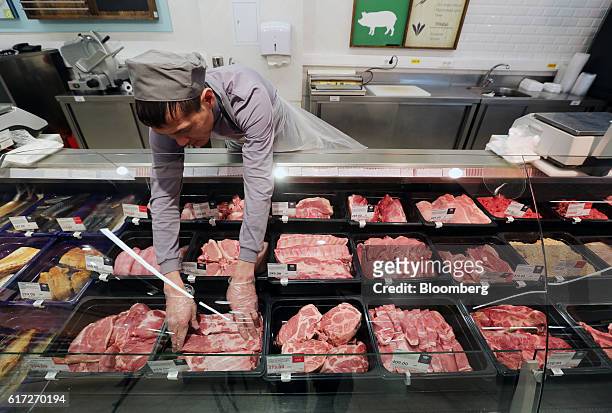 An employee arranges meat products at a counter inside a Victoria supermarket operated by Dixy Group PJSC in Moscow, Russia, on Friday, Oct. 21,...