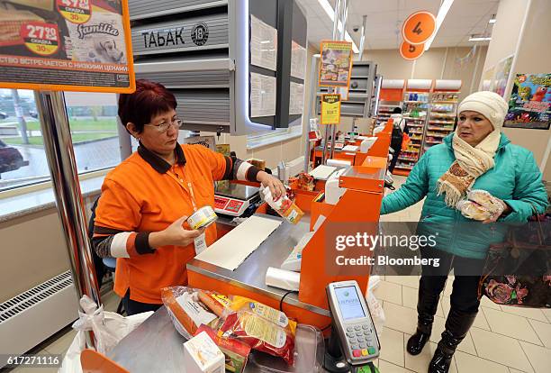 An employee scans items for a customer at the checkout inside supermarket operated by Dixy Group PJSC in Moscow, Russia, on Friday, Oct. 21, 2016....