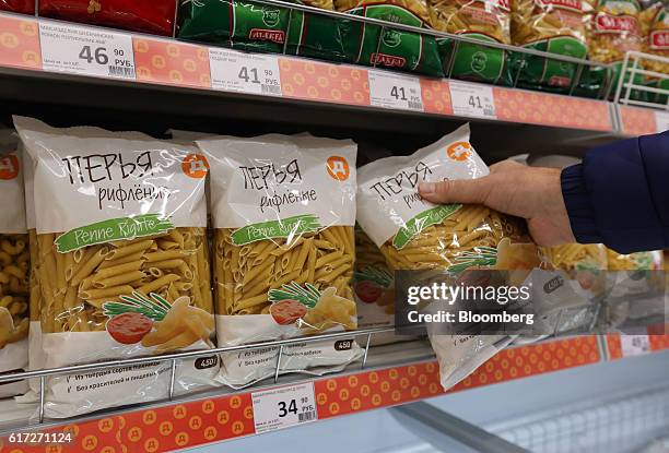 Customer selects a packet of pasta from the shelf inside a supermarket operated by Dixy Group PJSC in Moscow, Russia, on Friday, Oct. 21, 2016. The...