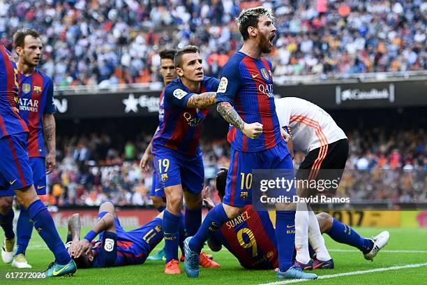 Lionel Messi of FC Barcelona celebrates with his team mates as Neymar Jr. And Luis Suarez reacts on the pitch after being hit by objects thrown from...