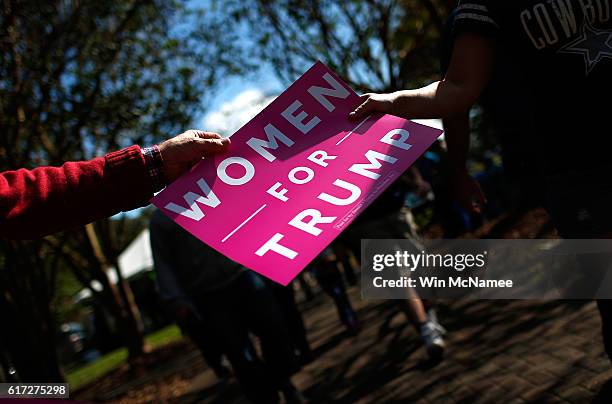 Volunteers pass out "Women For Trump" signs before a campaign event featuring Republican presidential candidate Donald Trump at Regent University...