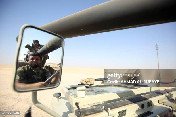 Shiite fighters from the Popular Mobilization Forces arrive in an area south of Mosul, on October 22 during an operation to retake the main hub city...