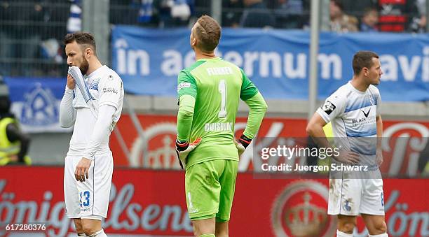 Players of Duisburg stand on the pitch LtoR Zlatko Janjic, goalkeeper Mark Flekken and Thomas Broeker after the third league match between MSV...