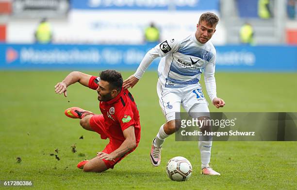 Nico Klotz of Duisburg tackles Kerem Buelbuel of Rostock during the third league match between MSV Duisburg and Hansa Rostock at...