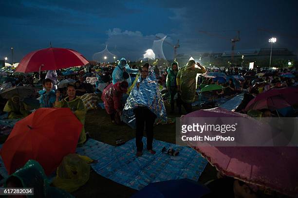 Thailand Mourners in the rain dressed in black gathers around the Grand Palace as they attends to perform the Royal Anthem at Sanam Luang in Bangkok,...