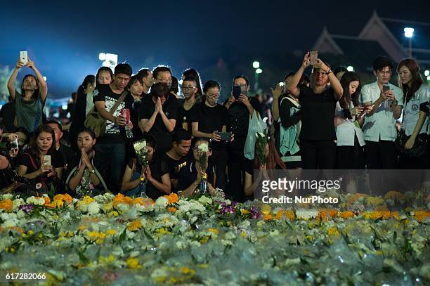 Thai mourner offers flowers as she prays for late Thai King Bhumibol Adulyadej outside the Grand Palace in Bangkok, Thailand, on October 22, 2016....