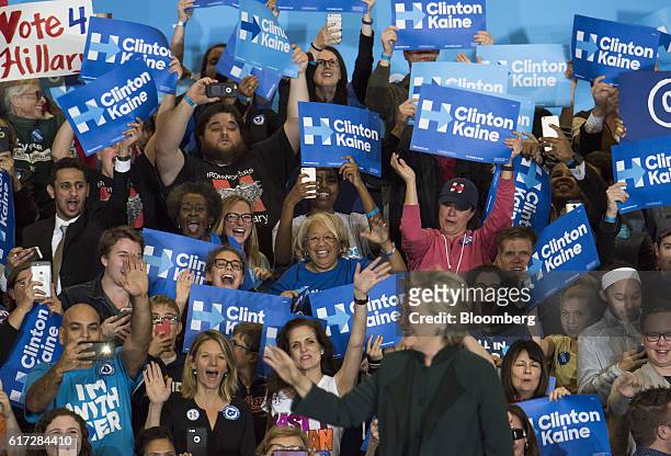 Attendees cheer as Hillary Clinton, 2016 Democratic presidential nominee, takes the stage before speaking during a campaign rally in Cleveland, Ohio,...