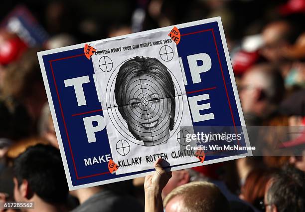 Supporter of Republican presidential candidate Donald Trump holds a picture of Democratic presidential candidate Hillary Clinton superimposed over a...