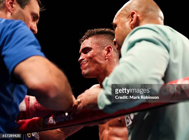 Anthony Ogogo Of England is puled out by his trainer Tony Sims during the 8th round against Craig Cunningham Of England during their WBC...