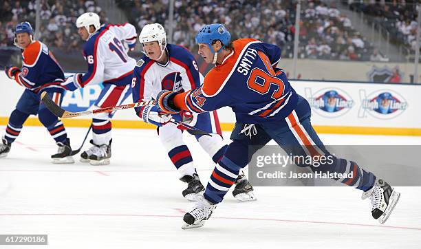 Ryan Smith of the Edmonton Oilers alumni shoots in front of Jim Kyte of the Winnipeg Jets alumni during the 2016 Tim Hortons NHL Heritage Classic...