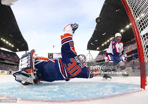 Teemu Selanne of the Winnipeg Jets alumni gets the puck past Bill Ranford of the Edmonton Oilers alumni to score a first period goal during the 2016...