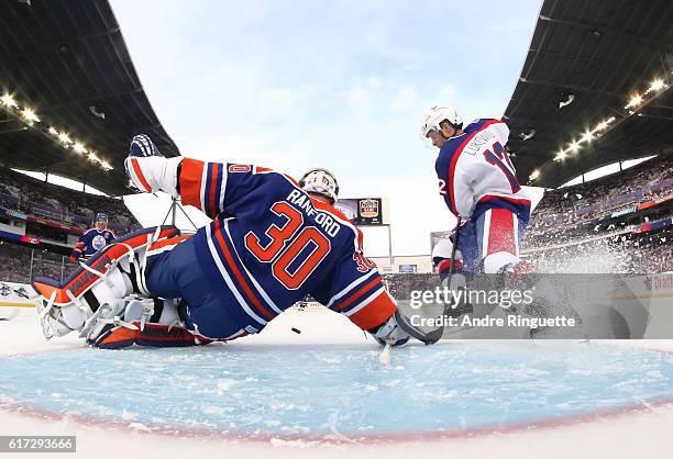 Morris Lukowich of the Winnipeg Jets alumni jumps on a loose puck in front of Bill Ranford of the Edmonton Oilers alumni during the 2016 Tim Hortons...