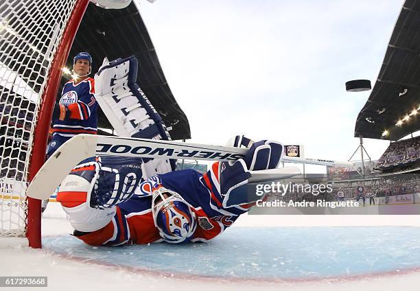 Winnipeg Jets alumni gets the puck past Bill Ranford of the Edmonton Oilers alumni during the 2016 Tim Hortons NHL Heritage Classic alumni game at...