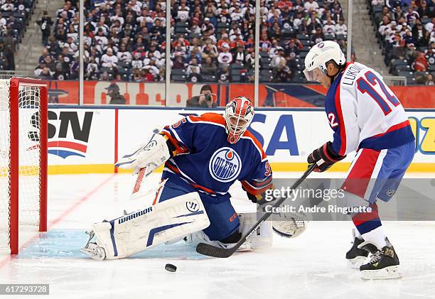 Morris Lukowich of the Winnipeg Jets alumni battles for a loose puck with Dwayne Roloson of the Edmonton Oilers alumni during the 2016 Tim Hortons...