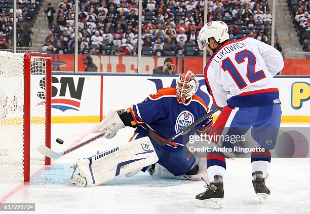 Morris Lukowich of the Winnipeg Jets alumni fires a shot on Dwayne Roloson of the Edmonton Oilers alumni during the 2016 Tim Hortons NHL Heritage...