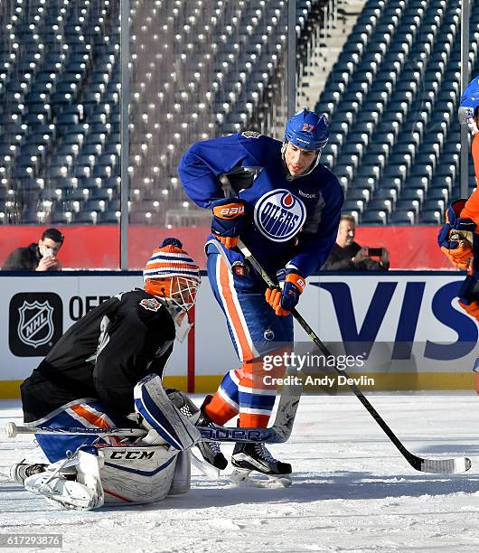 Milan Lucic battles in front of Cam Talbot of the Edmonton Oilers during practice in advance of the 2016 Tim Hortons NHL Heritage Classic game at...