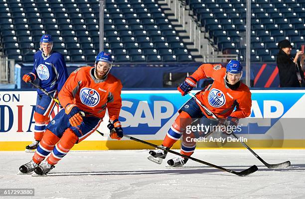 Eric Gryba and Oscar Klefbom of the Edmonton Oilers skate during warmup in advance of the 2016 Tim Hortons NHL Heritage Classic game at Investors...